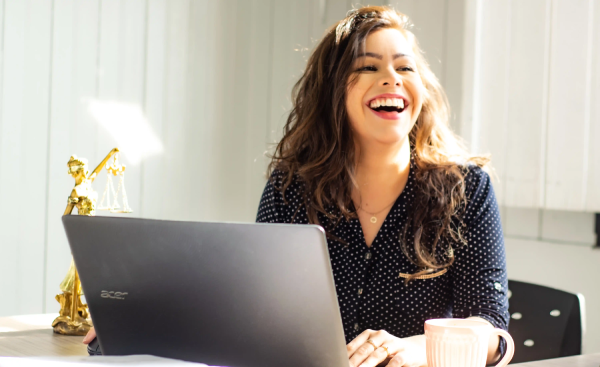 Photographie d'une femme riant dans son bureau