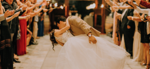 Photographie d'un mariage avec les époux au centre s'embrassant